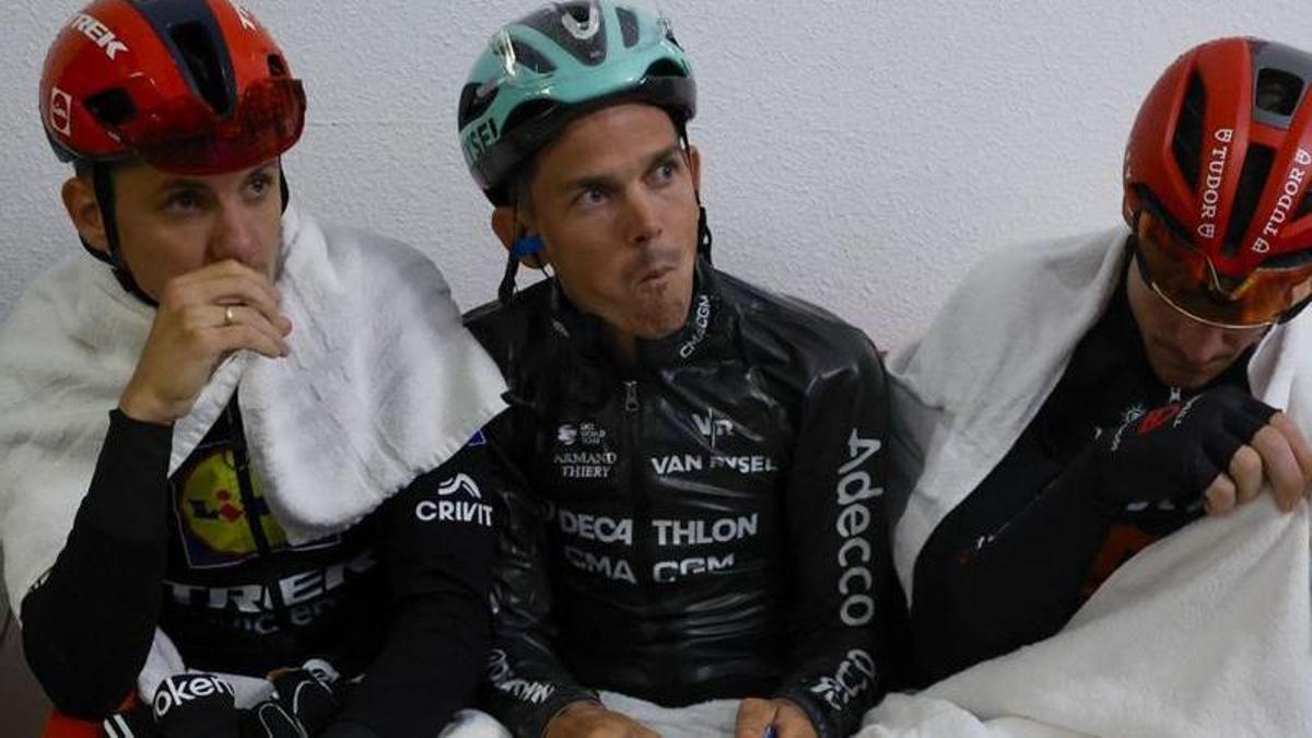 Diversos ciclistes s’eixuguen refugiats abans d’arribar a Font-romeu. | JAVIER LIZÓN / EFE
