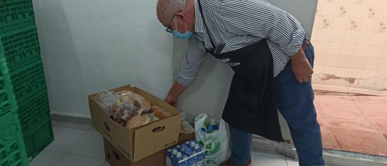 Un responsable de Alimentos Solidarios muesta el contenido de los lotes quincenales
