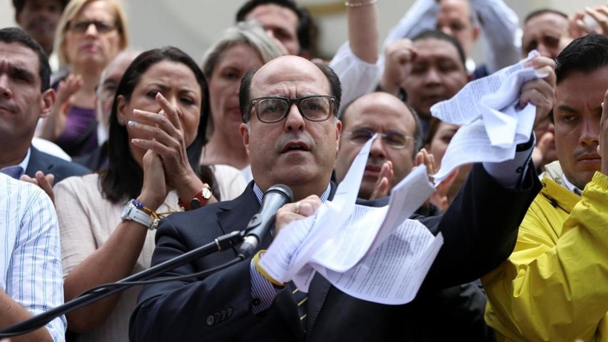 Julio Borges, presidente de la Asamblea nacional, rompe una copia de la sentencia del Supremo, en una rueda de prensa en Caracas, el 30 de marzo.