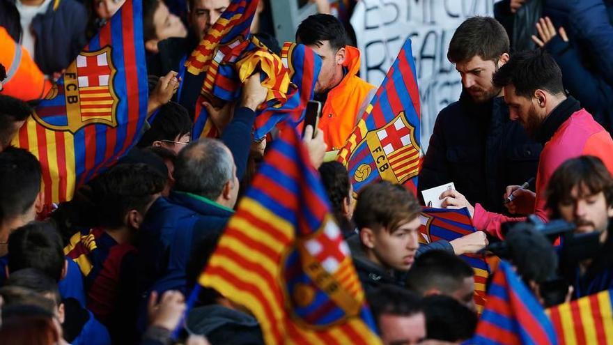 Messi, a la derecha, firma autógrafos al final del entrenamiento en el Miniestadi.