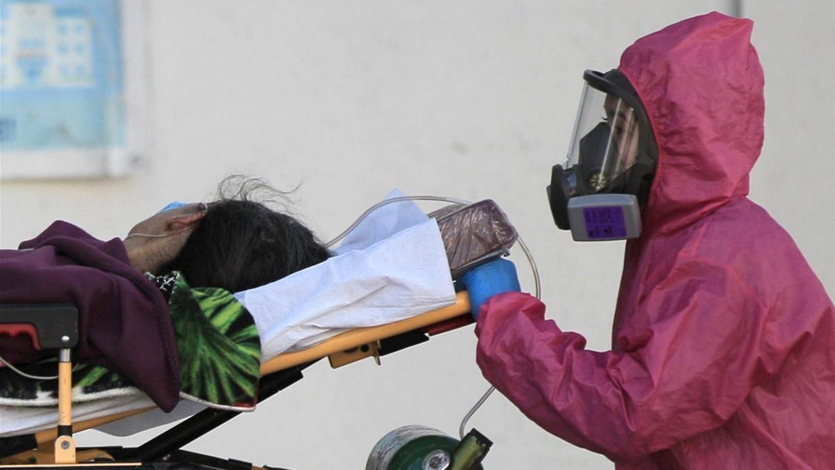 Un trabajador sanitario introduce  a una paciente enferma de covid-19 al Hospital General de Ciudad Juárez  en el estado de Chihuahua (México).