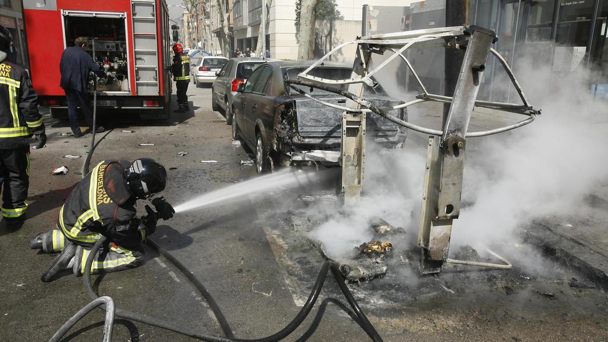 Un bombero de Barcelona apagando un contenedor incendiado, en una imagen de archivo.