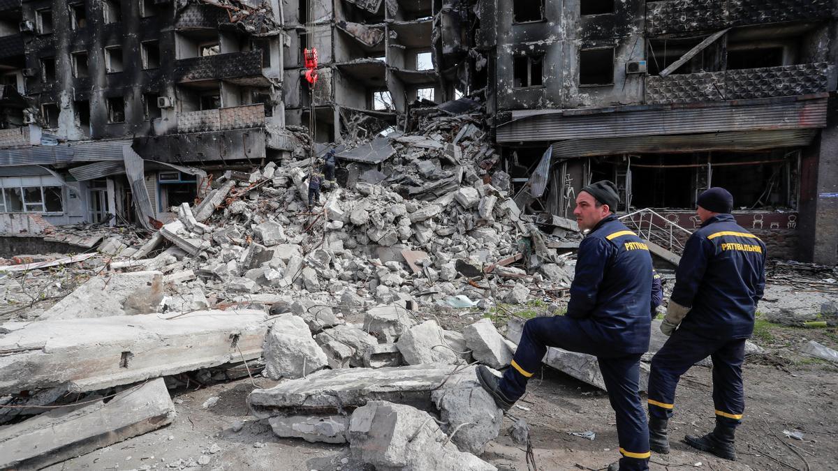 Trabajadores junto a un edificio destrozado en Mariúpol.