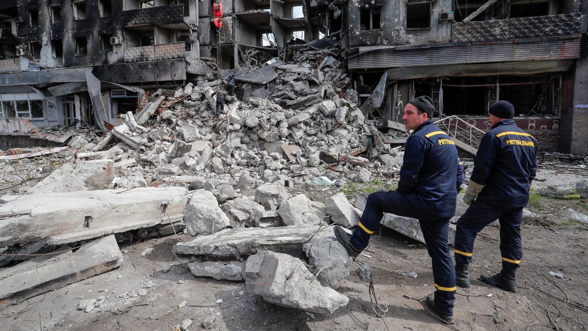 Trabajadores junto a un edificio destrozado en Mariúpol.