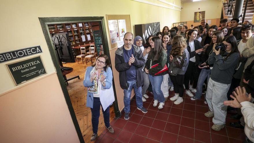 Carmen Calero, junto a la placa que da el nombre de Emilio Lledó a la biblioteca, y alumnos del IES Aramo. | IRMA COLLÍN