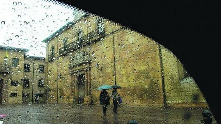 Dos mujeres con paraguas, ayer, en la Corrada del Obispo, en Oviedo.