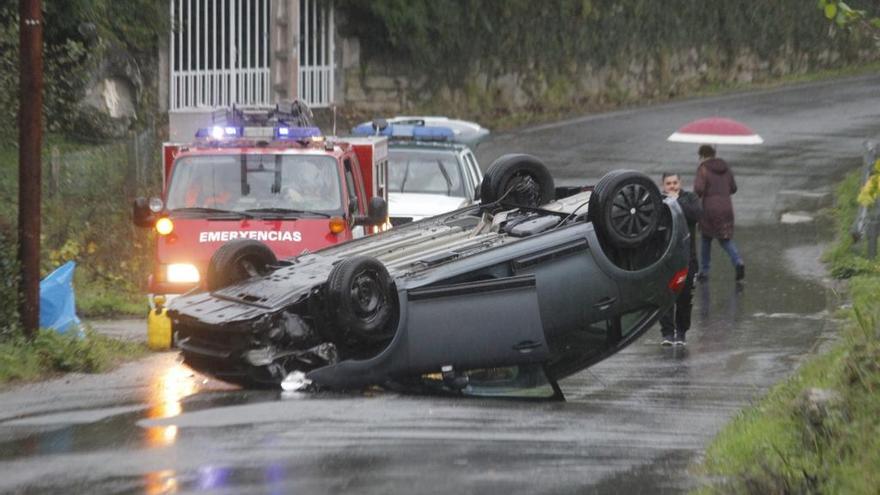 El coche volcado en medio de la carretera de Coiro.// Santos Álvarez