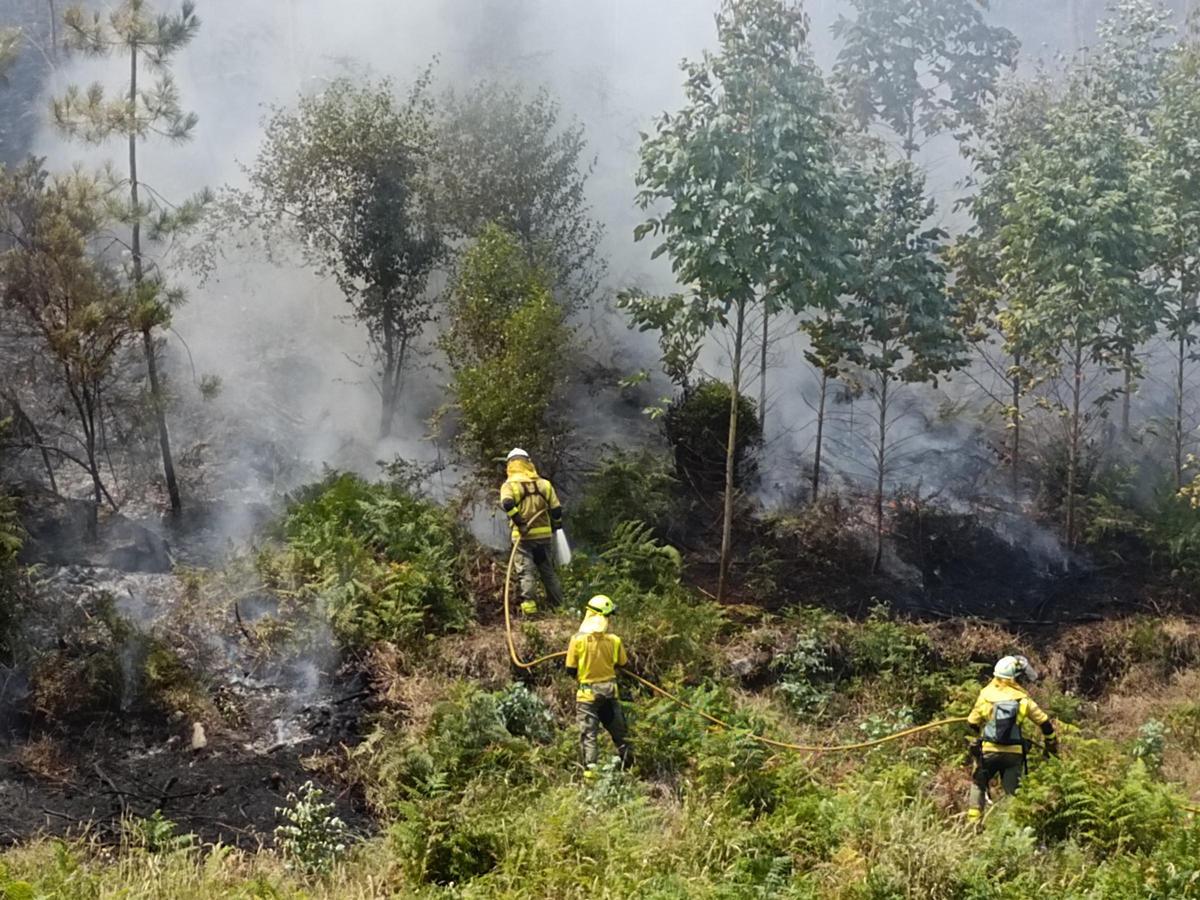 Una brigada refrescando una zona del incendio en la parroquia laxense de Nande.
