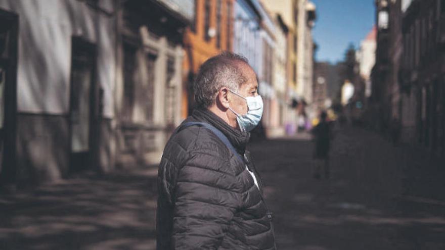 Un hombre de avanzada edad recorre las calles de La Laguna con su mascarilla.