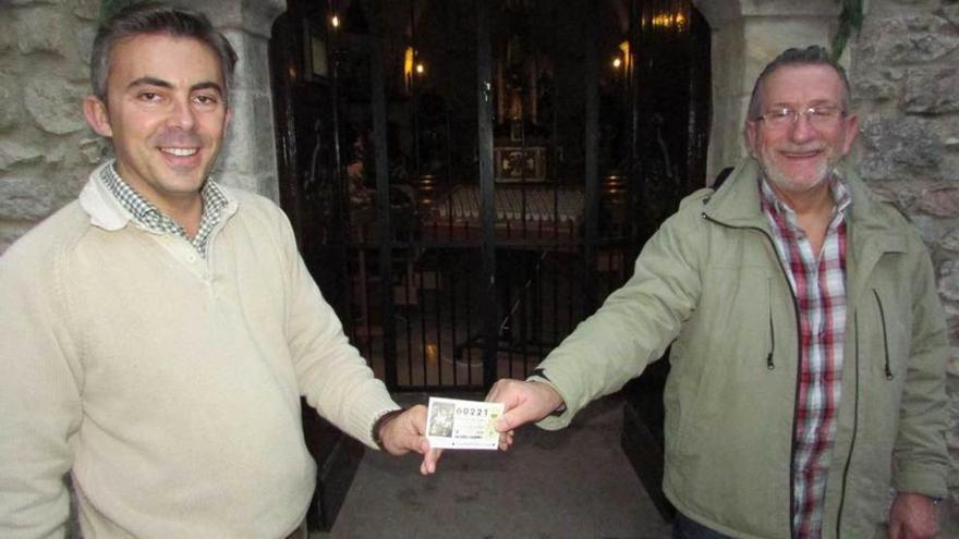 Raúl Herrero y Manolo Pumares, con el décimo premiado, delante de la capilla de La Magdalena.