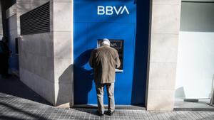 Un jubilado saca dinero de un cajero automático en Barcelona.