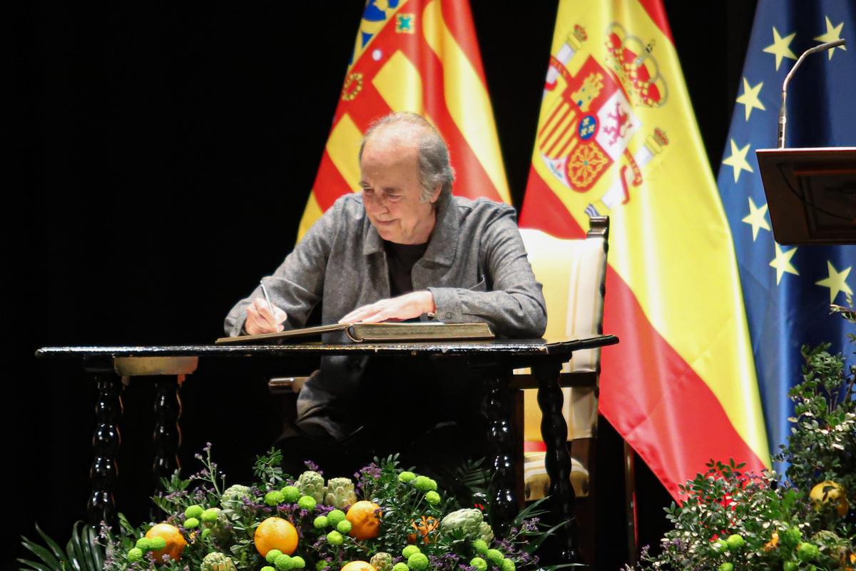 Serrat firma en el libro de honor del Ayuntamiento.