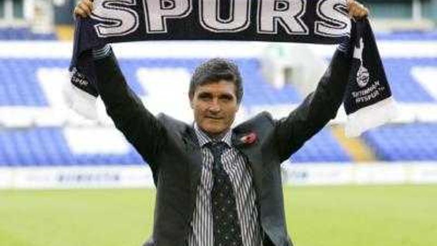 El entrenador de fútbol Juande Ramos posa con la bufanda de su nuevo equipo, el Tottenham Hotspurs, durante su presentación en el estadio de White Heart Lane en Londres.