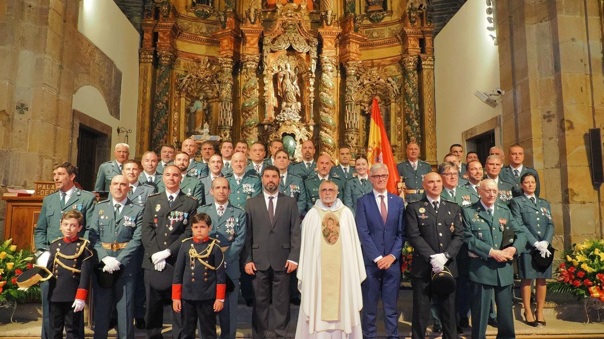 Foto de familia de los agentes de la Guardia Civil de Luarca y las autoridades en la iglesia, tras la misa.