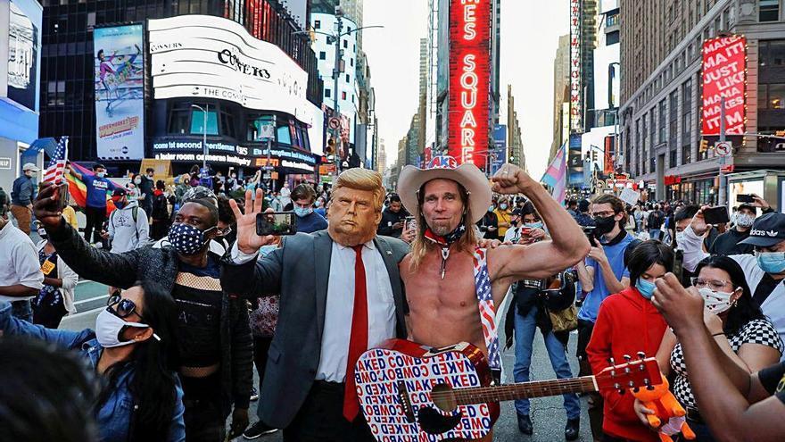 Un home disfressat de Trump i el famós vaquer nu de Nova York, en plena celebració.