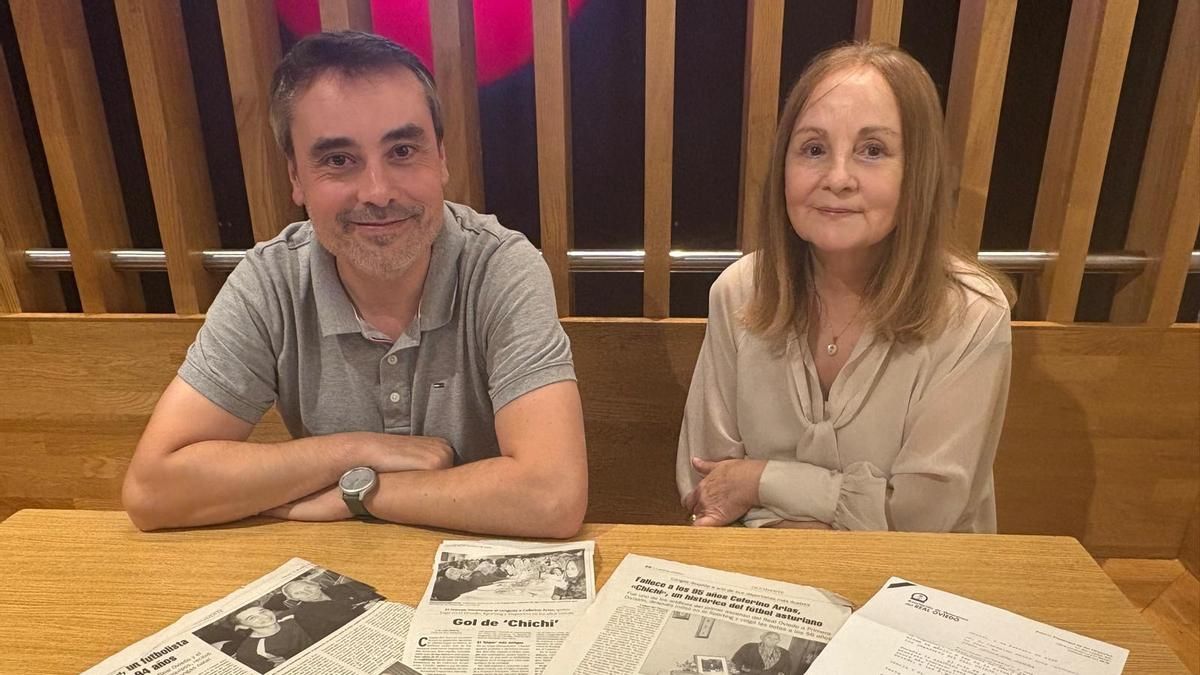 Pablo Paz y su madre Gala Arias, nieto e hija de Ceferino Arias "Chichi", con recortes de prensa sobre el futbolista cangués.