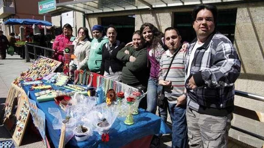 Arriba, público y tenderos en los puestos de productos hortícolas. A la izquierda, usuarios de Cogami-Deza vendiendo sus manufacturas. // Bernabé/Gutier