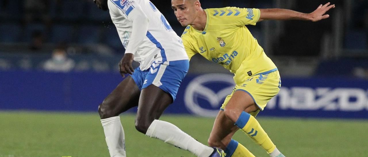 El amarillo Sergi Cardona persigue a Emmanuel Apeh durante el derbi del domingo pasado entre el Tenerife y la UD en el Heliodoro. | | LOF