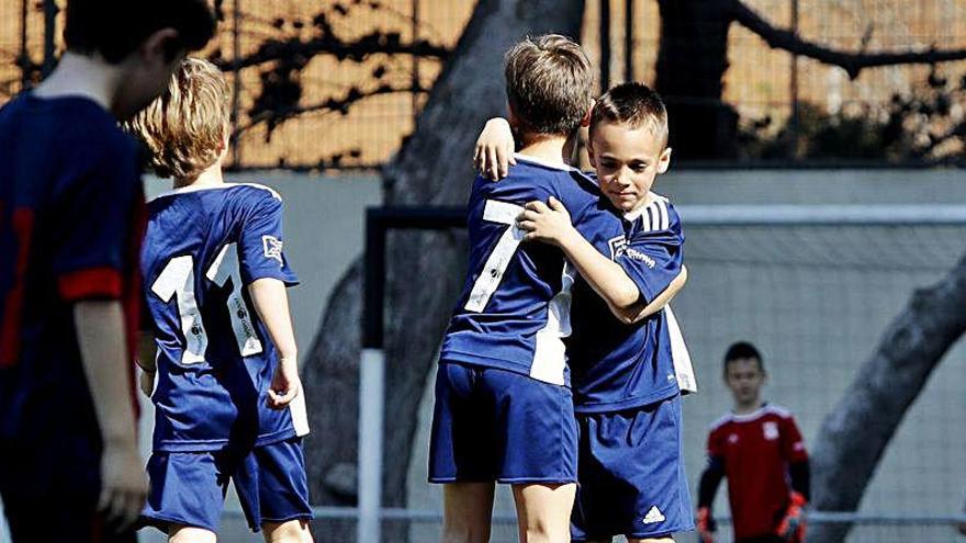 Unos jugadores de fútbol base celebran un gol.