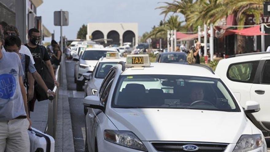 Cola de taxis llegando a la zona de recogida de pasajeros del aeropuerto.