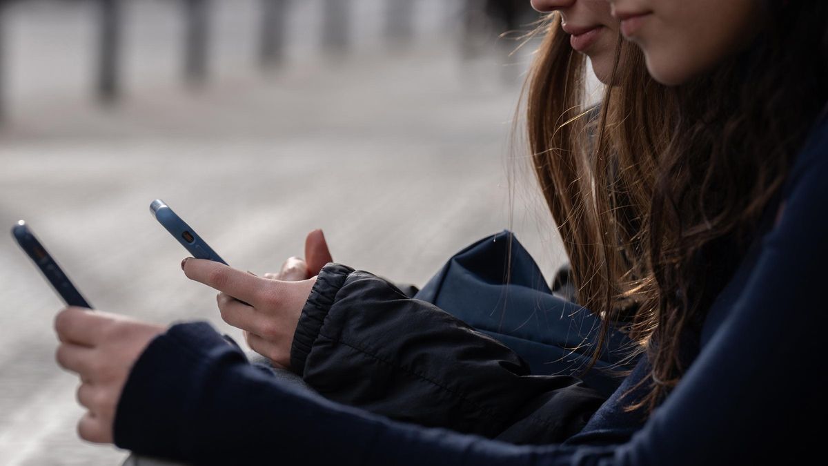Dos personas usan el móvil