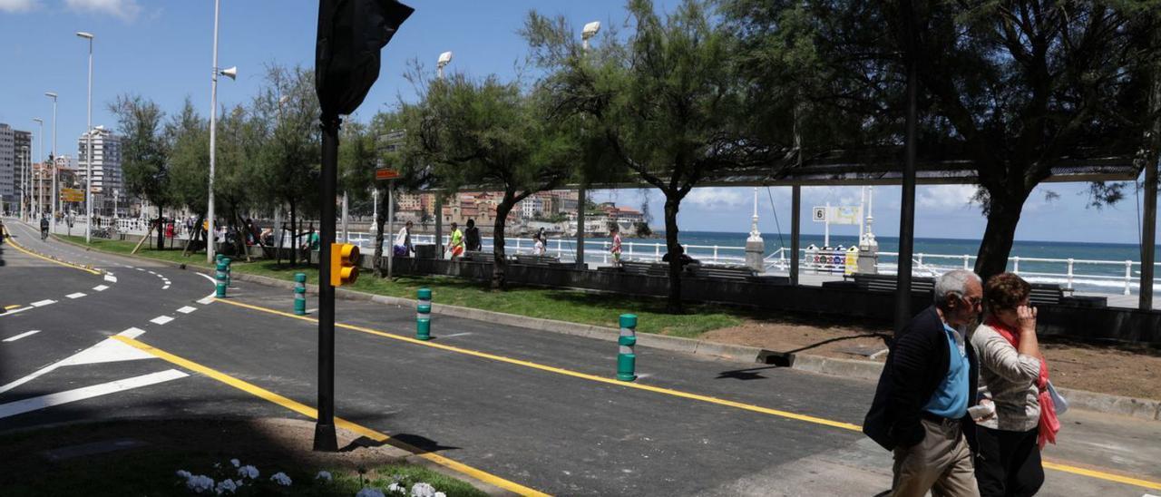 Paseantes por el «cascayu», a la altura de la calle Eladio Carreño, ayer, con nuevos semáforos y bolardos separando la senda verde y el carril bici. | Juan Plaza