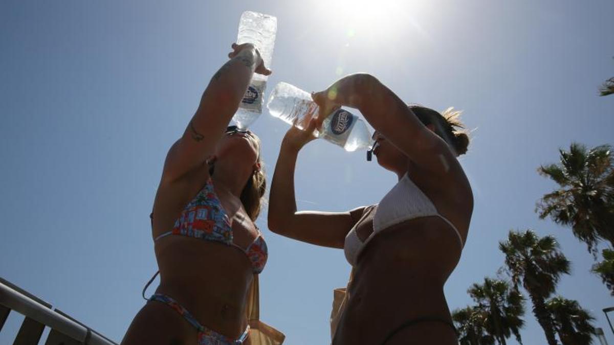 Dos mujeres beben agua en plena ola de calor en Barcelona durante un día de julio de 2024.