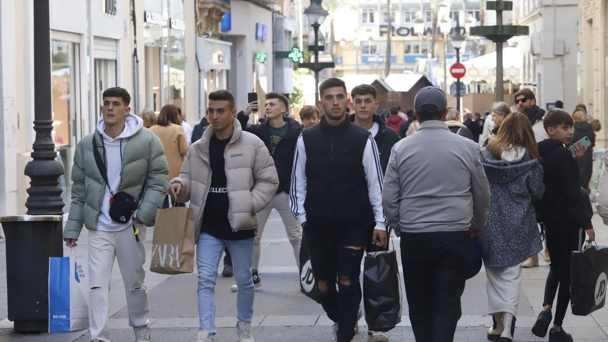 Jóvenes de compras durante la mañana del Black Friday en la calle Gondomar.