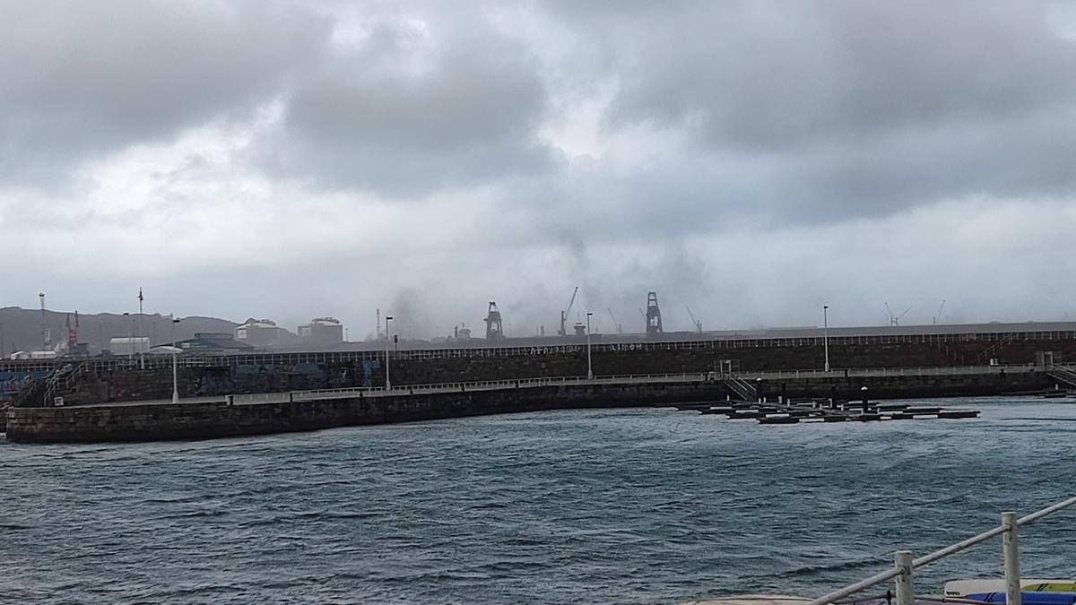 El fuerte viento levanta una espectacular nube negra de carbón en Gijón