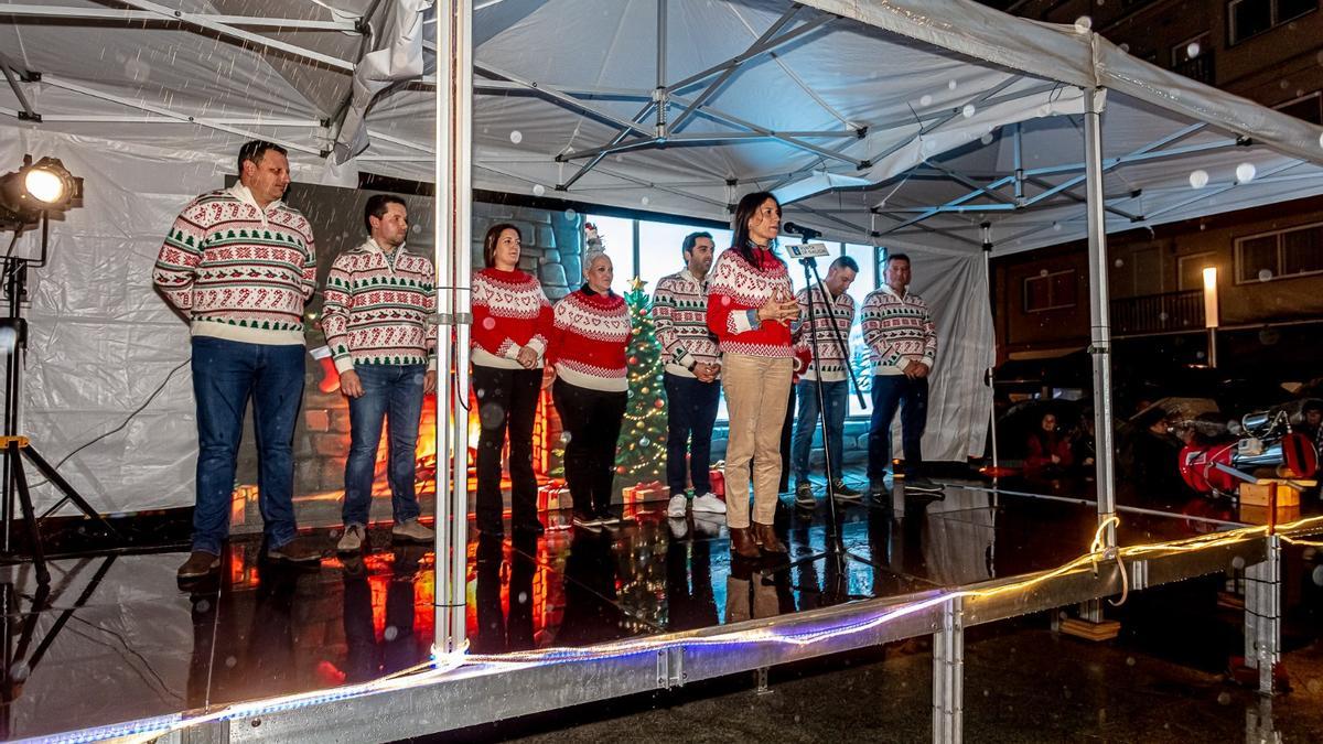 A conselleira de Vivenda, María M. Allegue, ataviada a xogo co alcalde de Oroso e con concelleiros do Goberno municipal, participou no acendido da iluminación de Nadal na Praza Isaac Díaz Pardo.