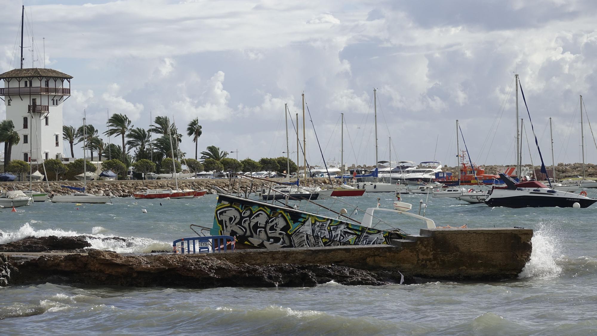 El oleaje destroza contra las rocas de Portals un barco varado