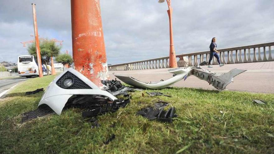 Restos del parachoques del coche accidentado junto a la farola contra la que chocó.