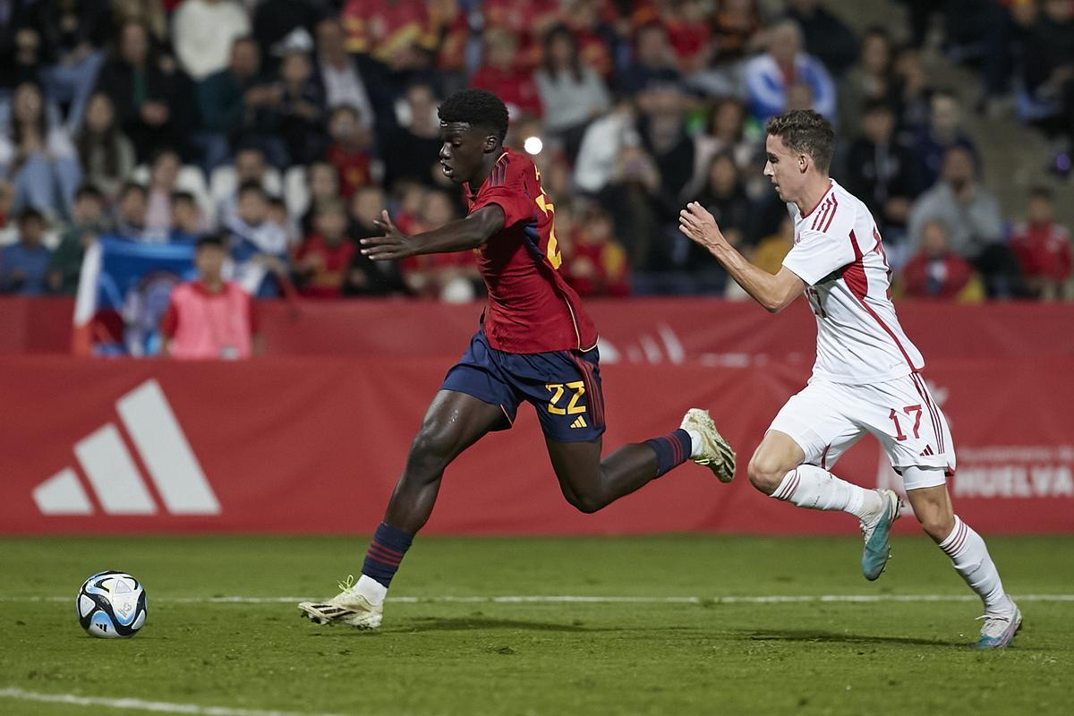  El delantero de la selección española sub-21 Assane Diao se escapa de Mátyás Kovács, de la selección de Hungría, durante el partido valedero para estar en la Eurocopa de 2025 que las selecciones sub-21 de España y Hungría juegan hoy viernes en el estadio Nuevo Colombino, en Huelva. 