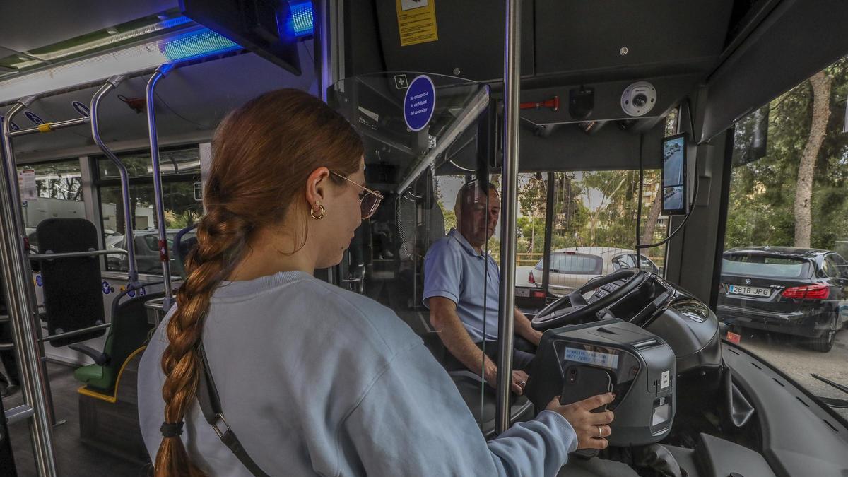 Una usuaria paga el autobús urbano de Elche con teléfono móvil