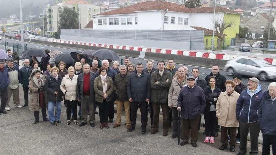 Javier bas, Ignacio López-Chaves y concejales reondelanos, ayer, rodeados por los vecinos de Chapela con el colegio Igrexa al fondo.  // Alba Villar