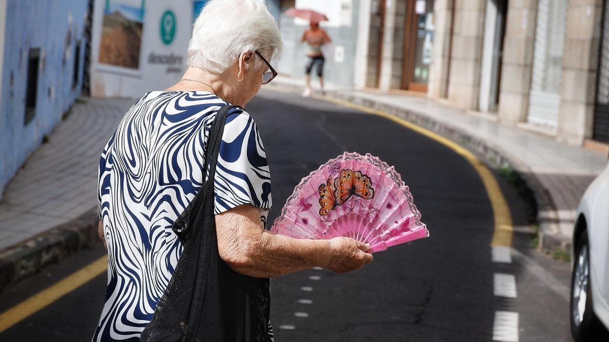 Una mujer se abanica para soportar el calor de la calle.