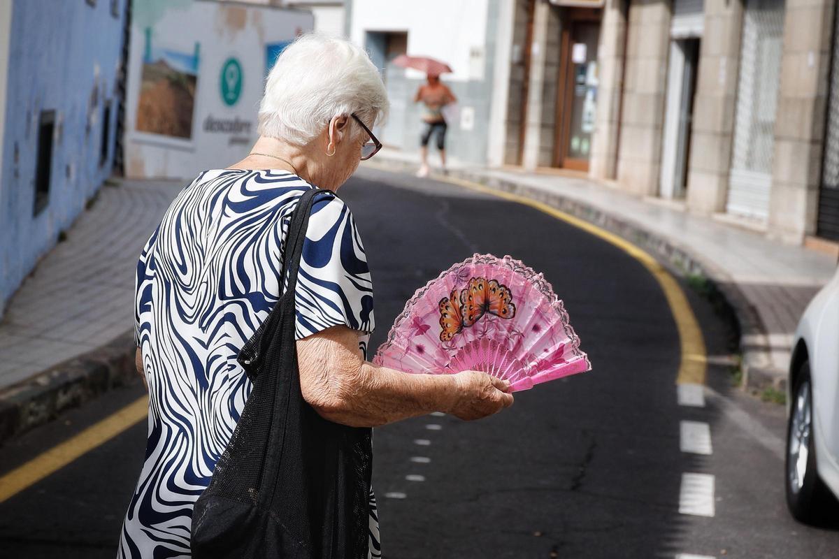 Una mujer se abanica para soportar el calor de la calle.