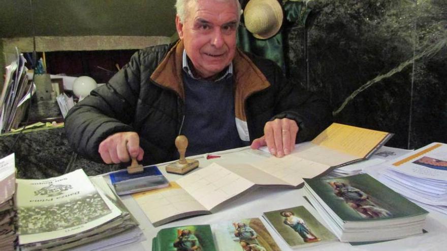 Guillermo Sordo en la capilla llanisca de San Roque, ayer, con una de las credenciales del Camino de Santiago que a diario sella en este lugar.