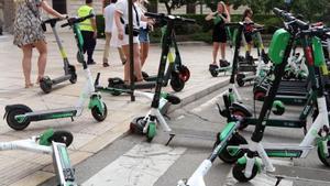 Varias usuarias alquilando patinetes eléctricos en el Centro de Málaga.