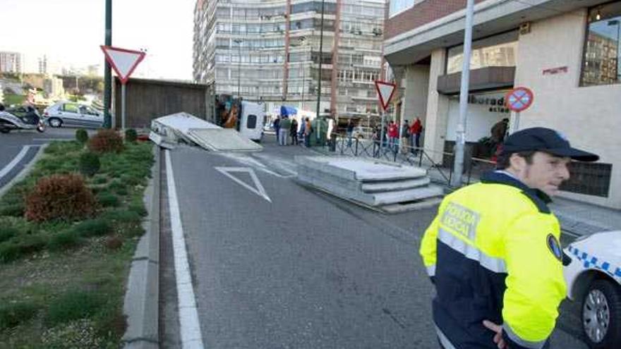 Un policía controla el tráfico en Isaac Peral poco después de volcar en la rotonda el camión cargado de piedra.