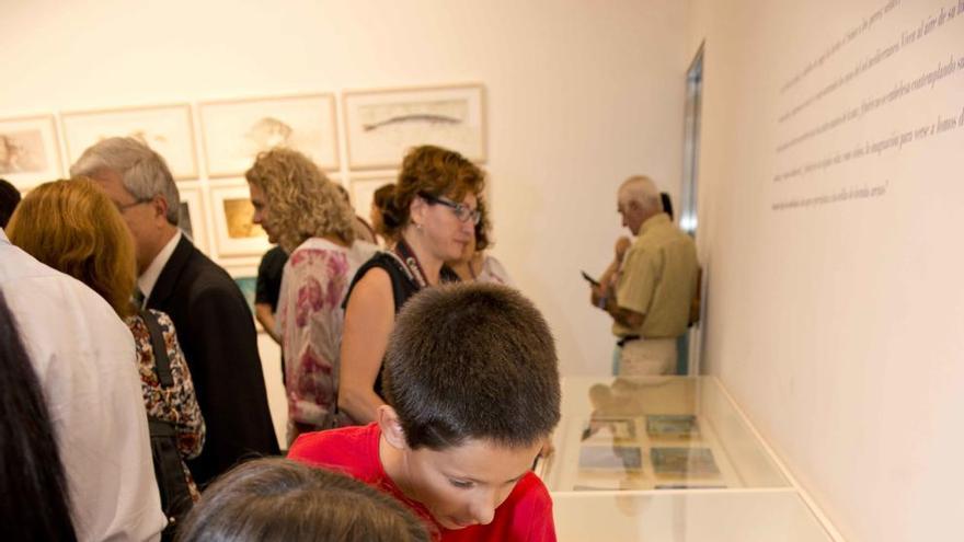 Varios visitantes observan las pintas de Pedro Cano.
