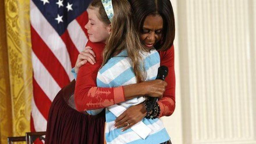 Una niña entrega a Michelle Obama el currículo de su padre parado