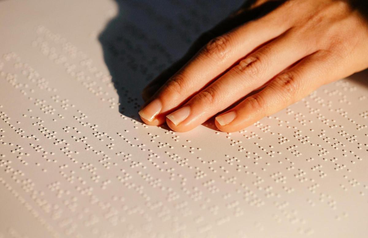 Una persona lee una página de braille, el sistema de lectoescritura que cumple 200 años.