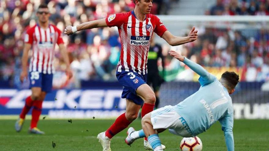 Emre Mor, de espaldas, disputa un balón al colchonero Filipe Luiz durante la última visita del Celta al Wanda Metropolitano. // Reuters