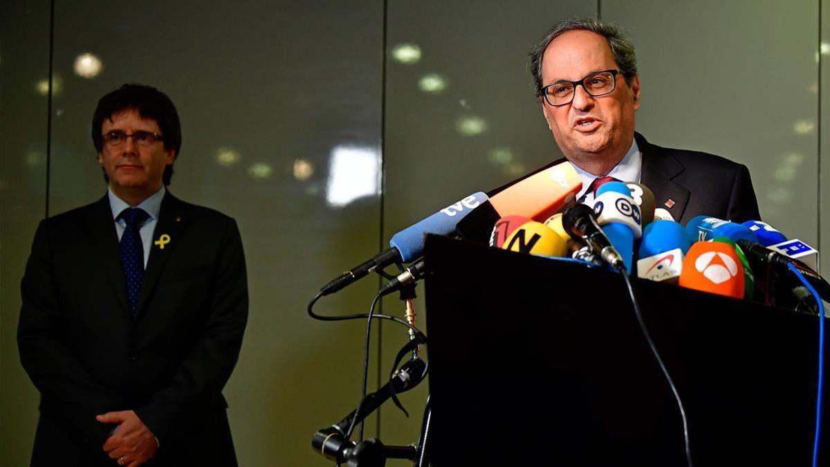 Quim Torra, en primer plano, y Carles Puigdemont, al fondo, en la rueda de prensa de este martes en Berlín.