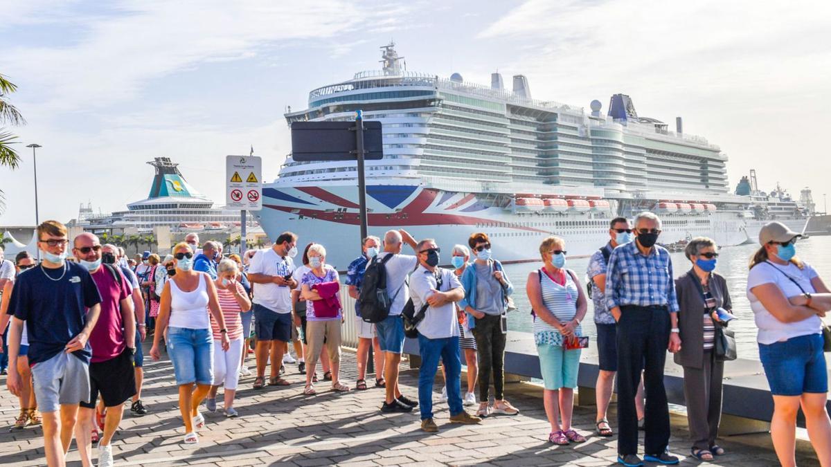 Turistas de uno de los cruceros que atracaron ayer en el puerto de Las Palmas de Gran Canaria, hacen cola para subir a la guagua y a los taxis. | | JUAN CASTRO