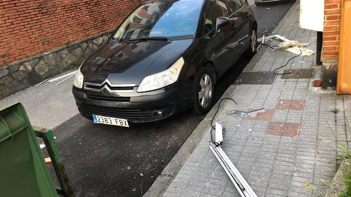 Restos de una ventana sobre un vehículo, tras la explosión