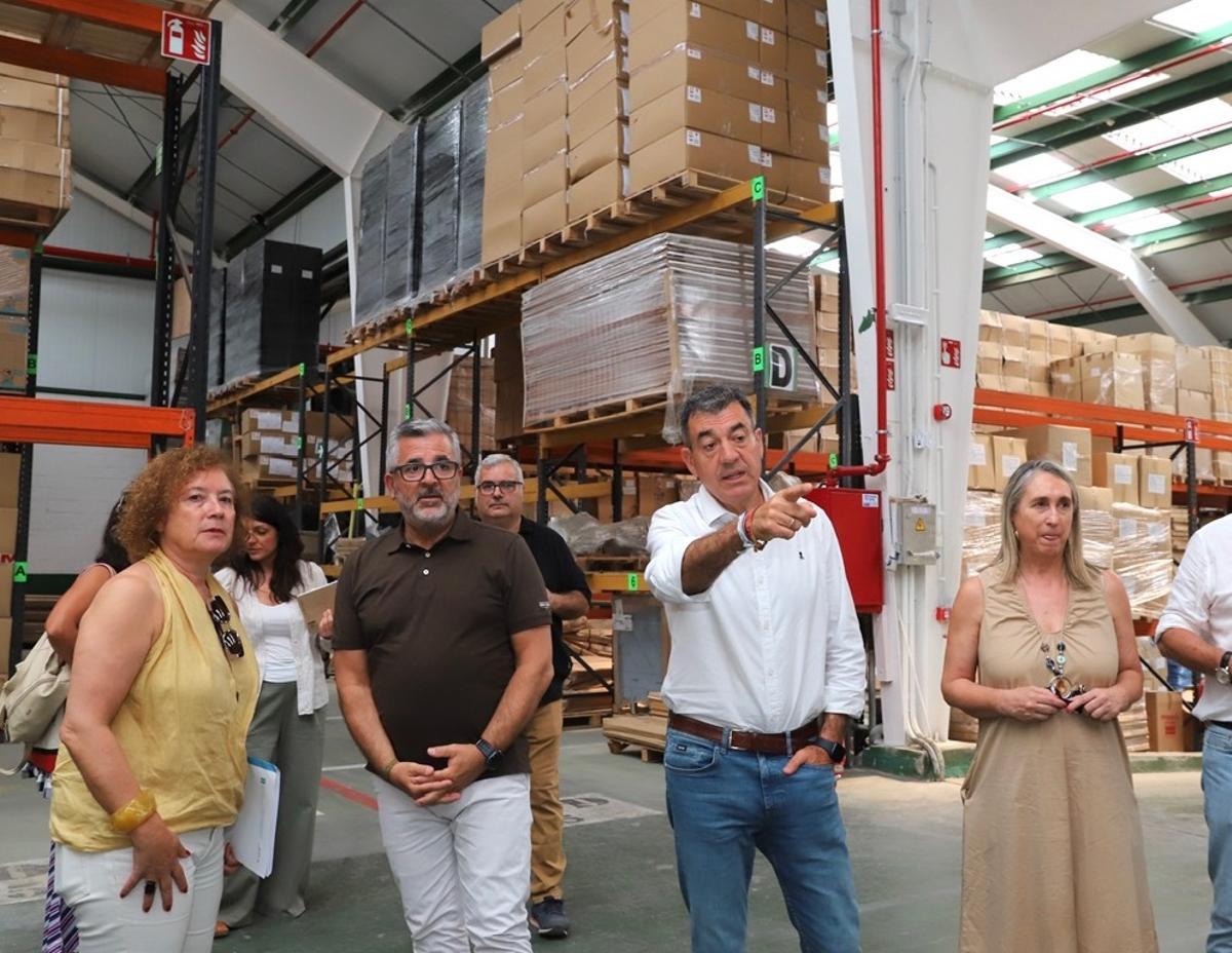 La subdirectora y el conselleiro, con responsables del almacén durante su visita