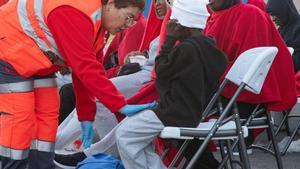 Una voluntaria de Cruz Roja atiende a una niña en recién llegada a Fuerteventura.69 personas en dos neumáticas a al sur de Canarias, entre ellas tres niños