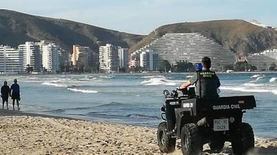 Un guardia civil patrulla con un quad por la orilla.